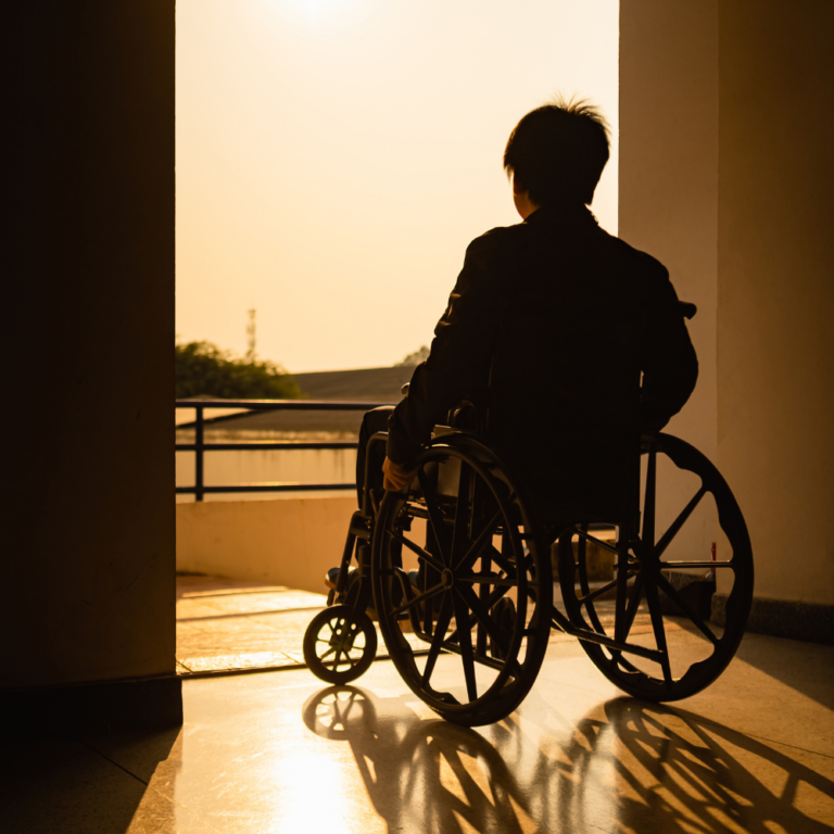 Nuori pyörätuolissa avoimen oven edessä